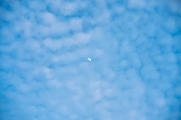 日中は雲が立ち並ぶ青空の美しい背景に月 水平射撃だ いい背景だ — ストック写真