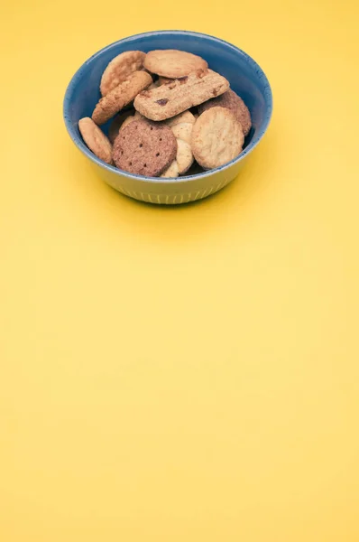 Вертикальний Знімок Органічного Печива Синій Мисці Жовтій Поверхні Копіювальним Простором — стокове фото