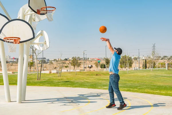 才能のある若い白人男性彼のバスケットボールのスキルを練習日当たりの良い公園で黒い帽子をかぶった — ストック写真