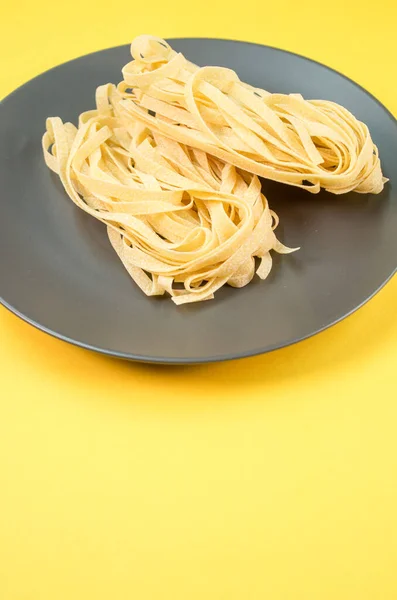 Een Bord Rauwe Pasta Geïsoleerd Een Gele Achtergrond Met Vrije — Stockfoto