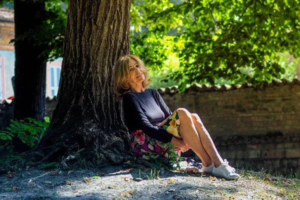 Щаслива Старенька Кавказька Жінка Вдень Сидить Під Деревом — стокове фото