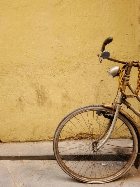 Pionowe Ujęcie Starego Opuszczonego Roweru Przed Żółtą Ścianą — Zdjęcie stockowe