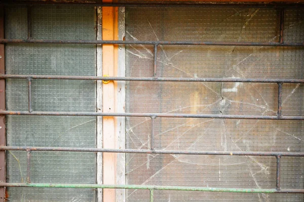 錆びたグリルの後ろに古い窓の壊れたガラス — ストック写真