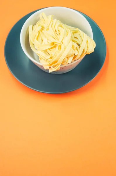 带有复制空间的橙色背景的一碗熟面食的详细视图 — 图库照片