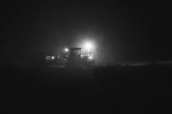 Een Straat Lamp Een Trekker Een Veld Tijdens Nacht — Stockfoto