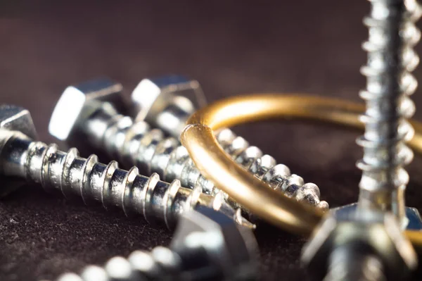 Zilveren Schroeven Een Gouden Ring Een Donker Oppervlak — Stockfoto