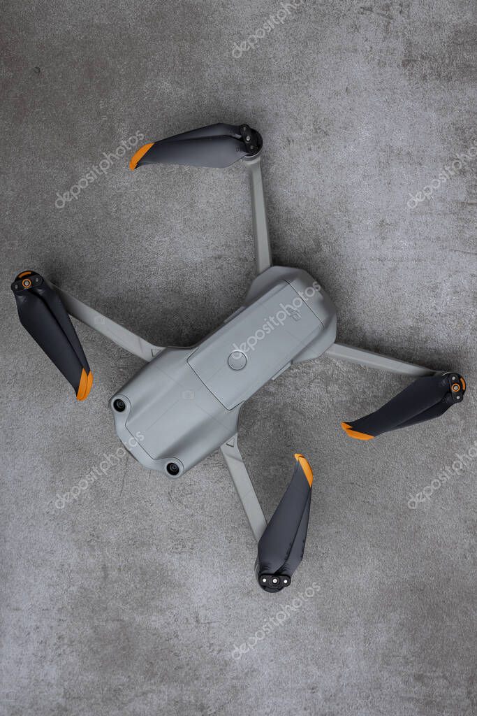 ZUTPHEN, NETHERLANDS - Aug 06, 2021: Slanted DJI Air 2S quadcopter drone with folded in props on a modern gray textured surface seen from above.
