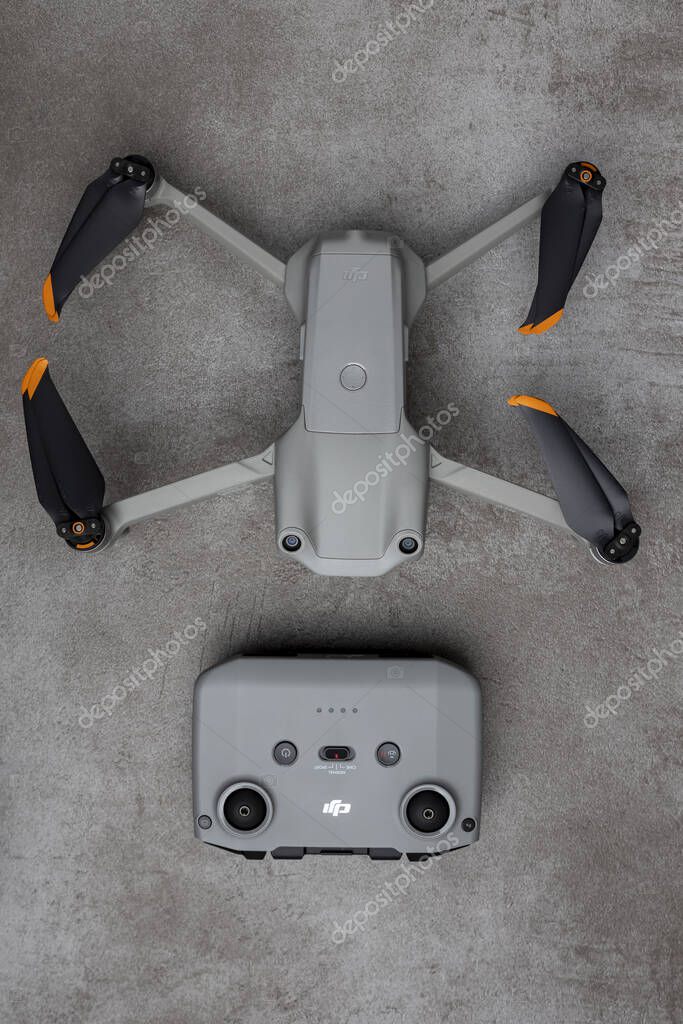 ZUTPHEN, NETHERLANDS - Aug 06, 2021: Top down view of DJI Air 2S quadcopter drone with remote control on gray stylish modern patterned surface.