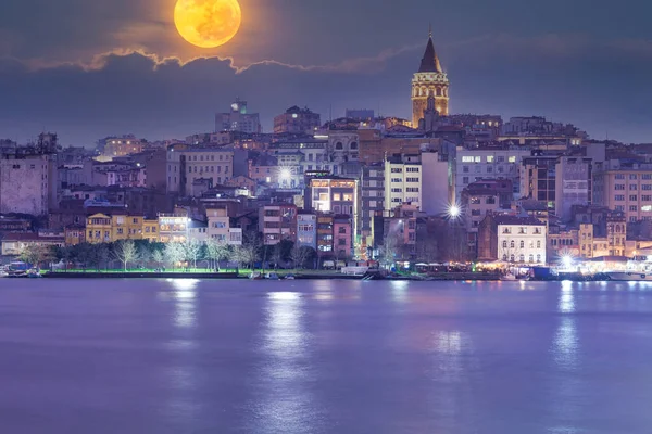 大きな黄色の満月と紫の星空の夜の間にトルコのイスタンブールの建物のショット — ストック写真