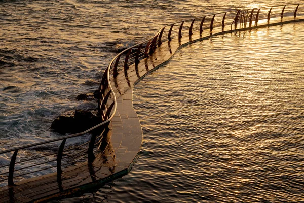 Uma Passarela Curva Superfície Água Sob Pôr Sol — Fotografia de Stock