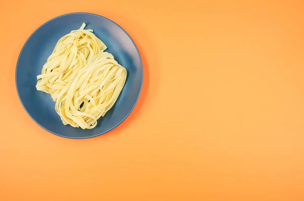 Ein Teller Rohe Pasta Isoliert Auf Orangefarbenem Hintergrund Mit Freiem — Stockfoto