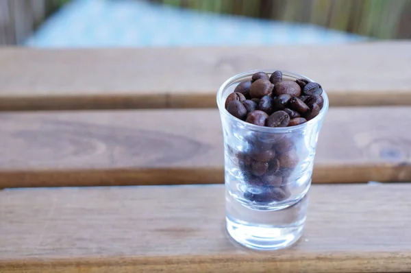 Close Shot Glass Full Black Coffee Beans Wooden Bench — Stock Photo, Image