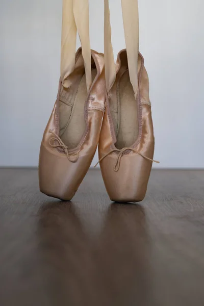 木制地板和白色背景上有橙色缎带的芭蕾舞拖鞋 — 图库照片