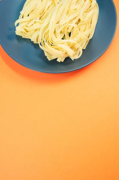 Een Bord Rauwe Pasta Geïsoleerd Een Oranje Achtergrond Met Vrije — Stockfoto