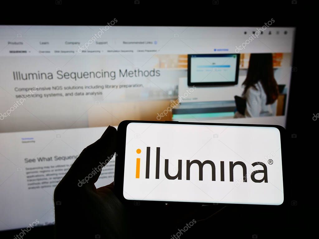 STUTTGART, GERMANY - Aug 15, 2021: Person holding smartphone with logo of genetics company Illumina Inc. on screen in front of website. Focus on phone display.