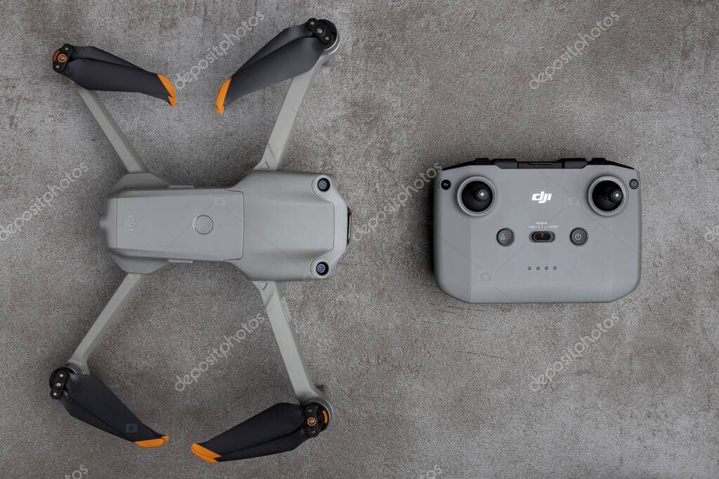 ZUTPHEN, NETHERLANDS - Aug 06, 2021: DJI Air 2S quadcopter drone with remote control seen from above on gray stylish modern patterned surface.
