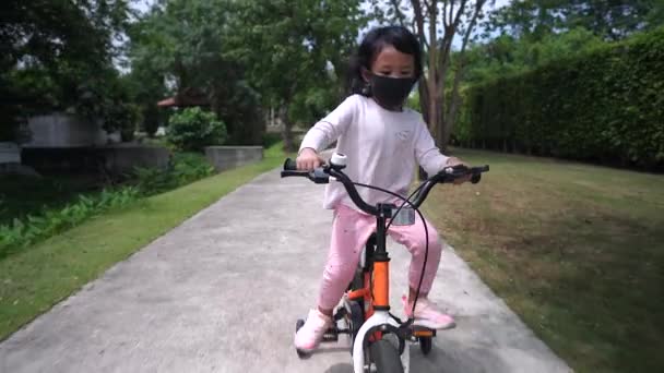 Cute Little Asian Girl Riding Bike Wearing Facial Mask — Stock video