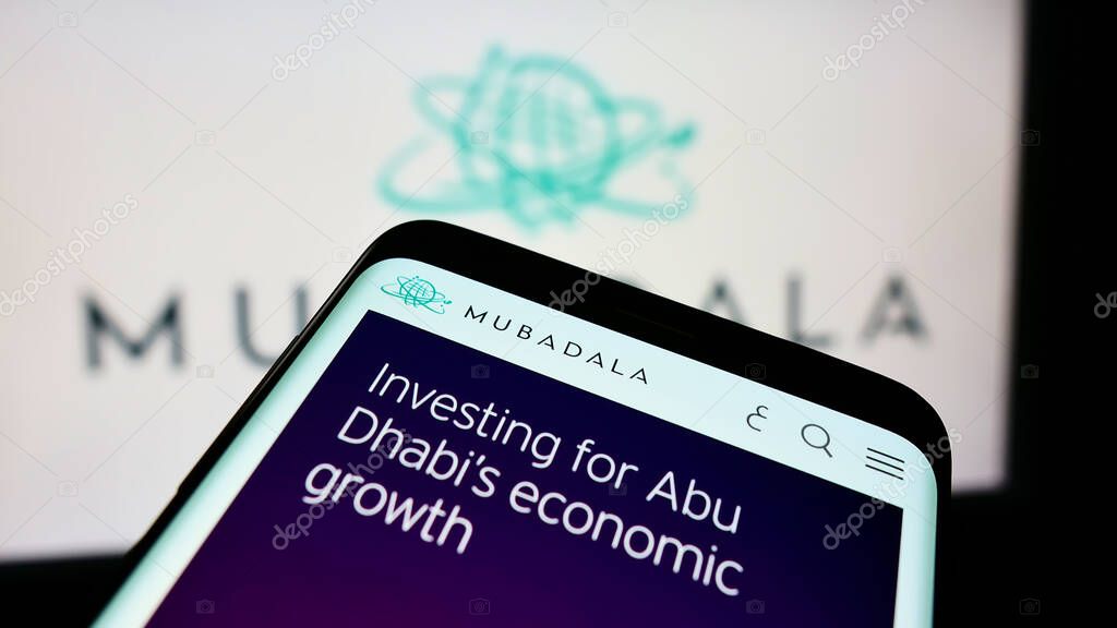 STUTTGART, GERMANY - Aug 23, 2021: Cellphone with webpage of investor Mubadala Investment Company PJSC on screen in front of logo. Focus on top-left of phone display.