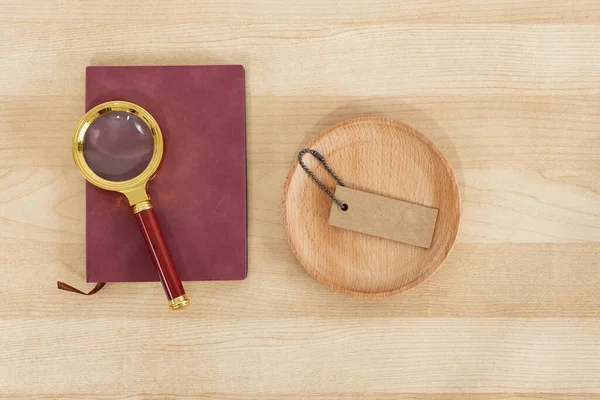 木製の背景に素朴なノートブック 虫眼鏡 および価格タグ — ストック写真