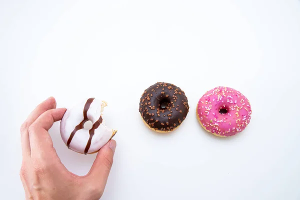 Uma Mão Tomando Pedaço Deliciosos Donuts Fundo Branco Com Espaço — Fotografia de Stock