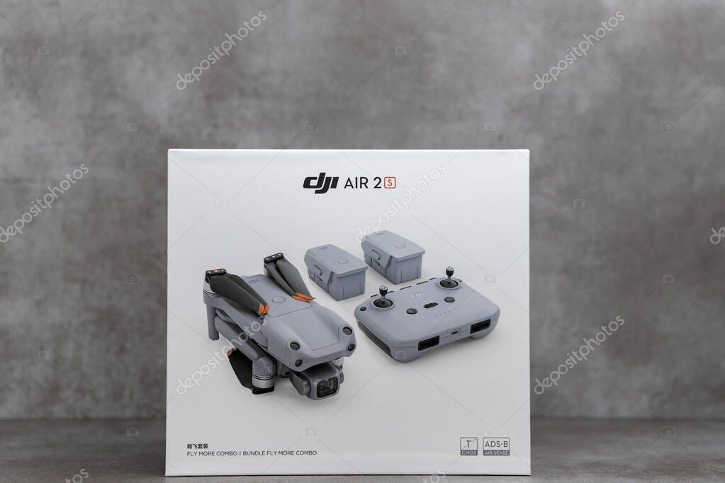 ZUTPHEN, NETHERLANDS - Aug 06, 2021: White fly more combo package box of DJI portable quadcopter Air 2S drone on stylish contemporary modern metallic patterned backdrop. Studio RPS still