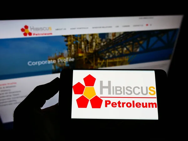 Stuttgart Germany Jun 2021 在商业网页上的屏幕上持有带有马来西亚Hibiscus Petroleum Berhad公司标志的手机的人 专注于电话显示 — 图库照片