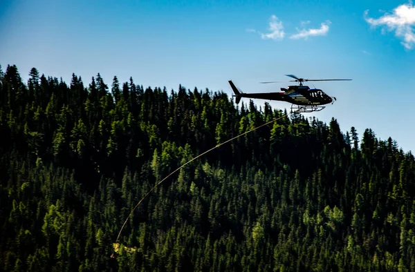 Closeup Shot Helicopter Rope Flying Mountains Covered Trees — Stock Photo, Image