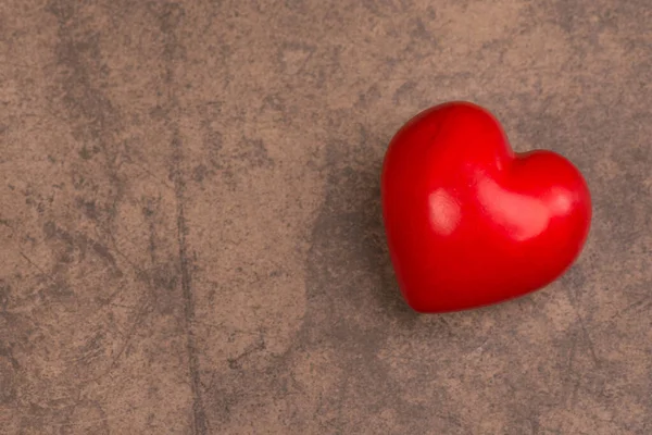 Kahverengi Bir Yüzeyde Kırmızı Kalp Şeklinde Bir Dekor — Stok fotoğraf