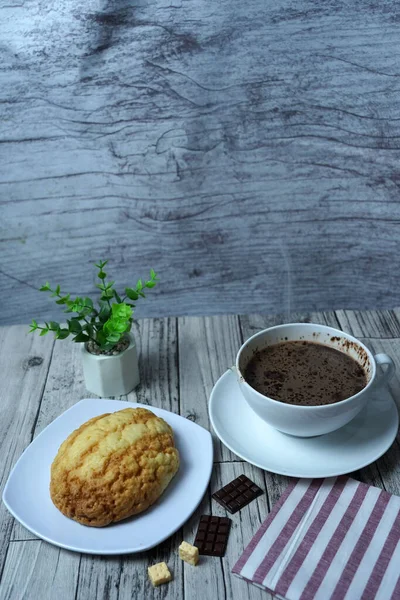 テーブルの上のプレート上にペストリーとホットチョコレートのカップの垂直ショット — ストック写真