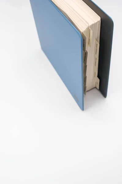 蓝色文件夹在白色表面上的一个蓝色文件夹的垂直截图 — 图库照片