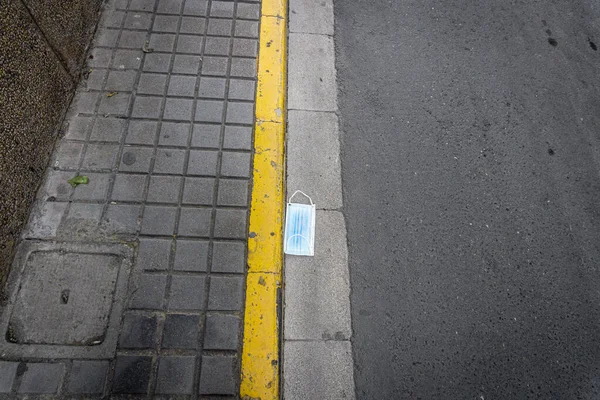 The protective medical mask on the street sidewalk near the markup
