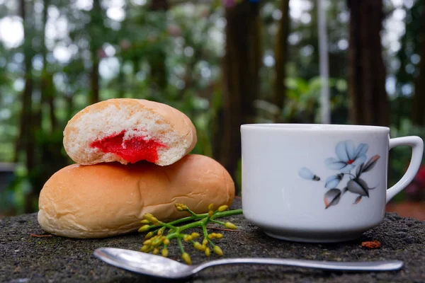 背景にはぼやけた森のお茶が入ったストロベリージャムのパンのクローズアップ — ストック写真