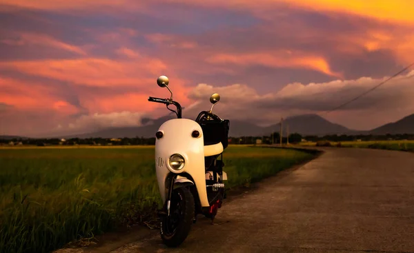 一辆白色的摩托车停在路边 在夕阳西下 — 图库照片