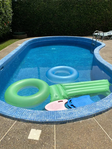 Outdoor Swimming Pool Green Blue Floaties Surrounded Grass Fence — Stock Photo, Image