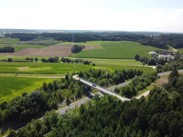 Krajina Mostu Přes Silnici Obklopená Zelení Pod Slunečním Světlem — Stock fotografie