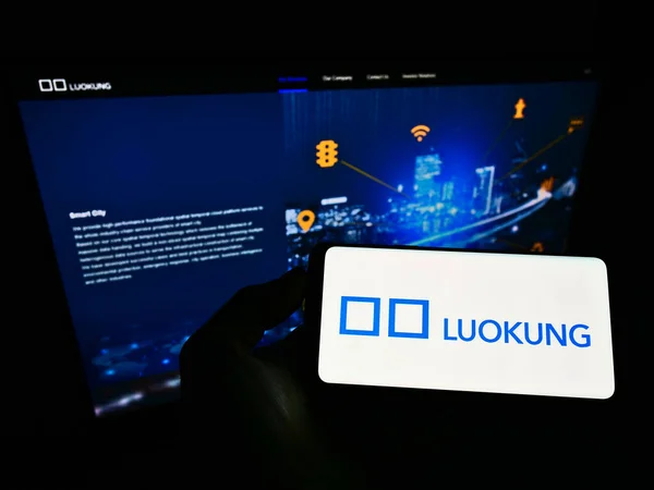 Stuttgart ドイツ 2021年6月8日 中国のデータ会社Luokung Technology Corp のロゴが入った携帯電話をビジネスウェブページの前の画面で所有している人 電話ディスプレイに焦点を当てる — ストック写真