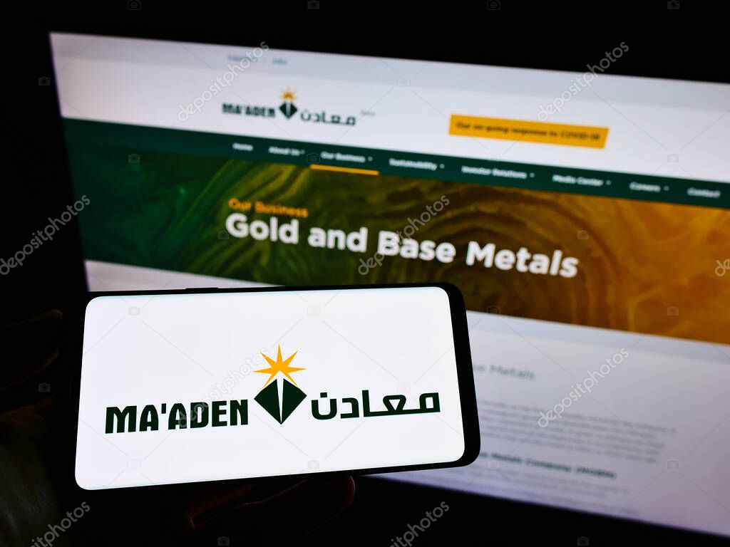 STUTTGART, GERMANY - Jun 08, 2021: Person holding cellphone with logo of company Saudi Arabian Mining Co. (MA'ADEN) on screen in front of business webpage. Focus on phone display.