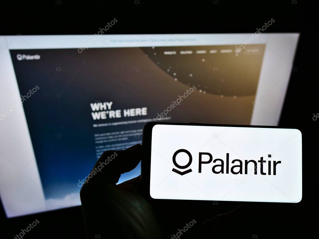 STUTTGART, GERMANY - Jun 07, 2021: Person holding smartphone with logo of US software company Palantir Technologies Inc. on screen in front of website. Focus on phone display.