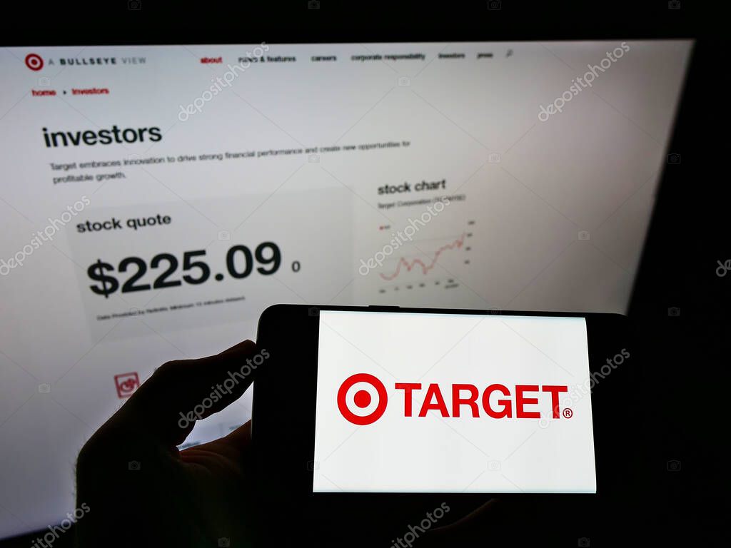 STUTTGART, GERMANY - Jun 03, 2021: Person holding smartphone with logo of US retail company Target Corporation on screen in front of website. Focus on phone display.