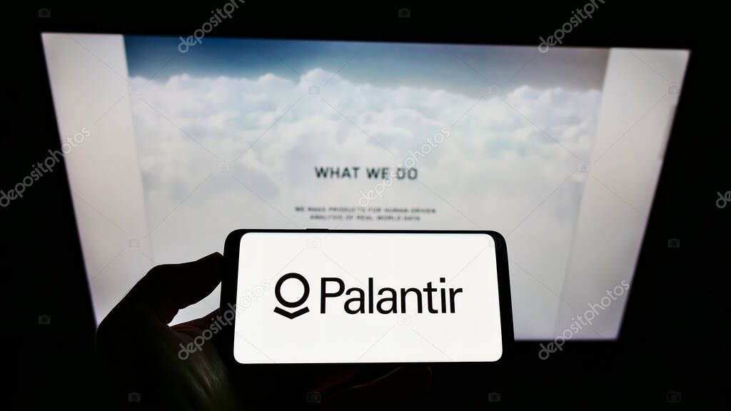 STUTTGART, GERMANY - Jun 07, 2021: Person holding cellphone with logo of Palantir Technologies Inc. on screen in front of webpage. Focus on phone display.
