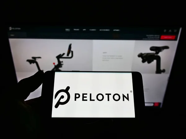 Stuttgart Germany Jun 2021 在商业网页前的屏幕上持有带有美国公司Peloton Interactive Inc 标识的手机的人 专注于电话显示 — 图库照片