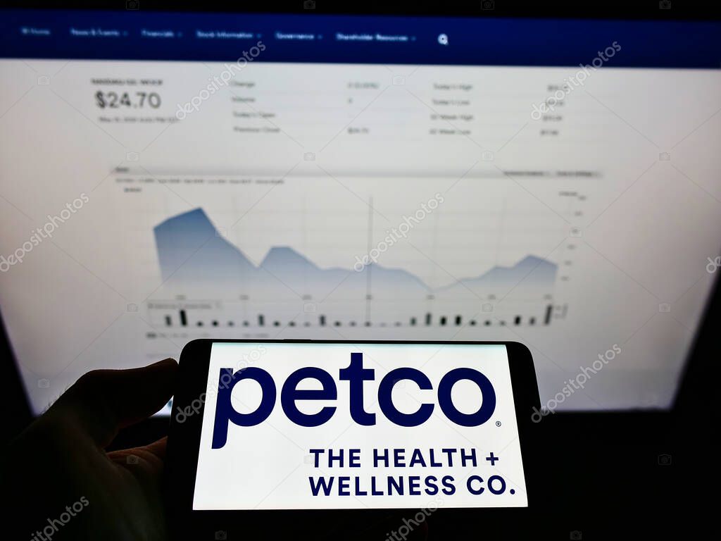 STUTTGART, GERMANY - Jun 02, 2021: Person holding smartphone with logo of US retailer Petco Health and Wellness Company Inc. on screen in front of website. Focus on phone display.