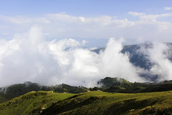 晴れた日には雲が降り積もる山あいの風景の高角度ショット — ストック写真