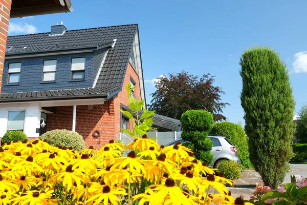 ウィルヘルムスハーフェン ドイツ 8月23 2021 晴れた日に茂みと黄色の花を持つ美しい郊外のクリンカーレンガ造りの家 前庭の装飾 — ストック写真