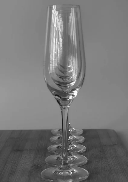 Closeup Grayscale Row Empty Champagne Glasses Wooden Table — Stock Photo, Image