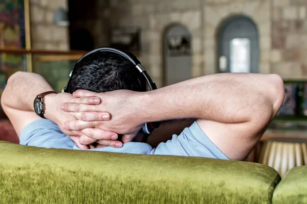 Orta Doğulu Genç Bir Adam Rahat Bir Kanepede Oturuyor Ellerini — Stok fotoğraf