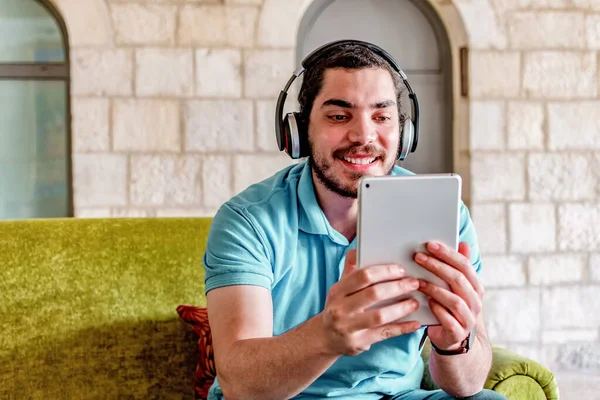 Joven Sonriente Hombre Oriente Medio Con Auriculares Viendo Divertido Video —  Fotos de Stock