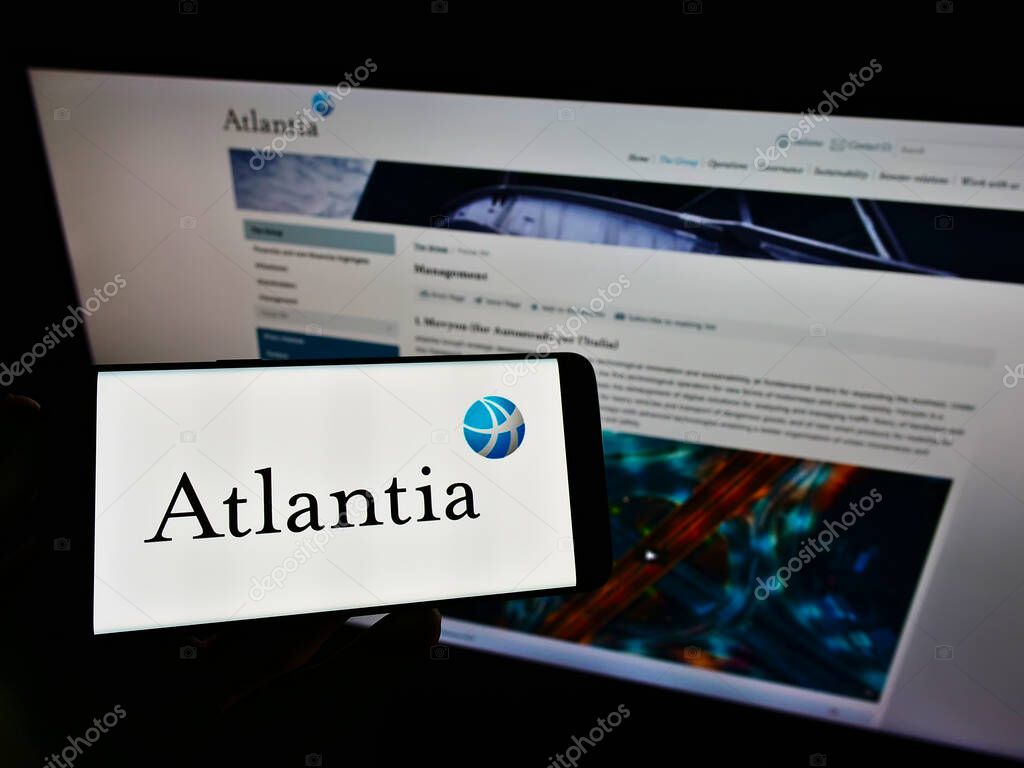 STUTTGART, GERMANY - May 30, 2021: Person holding cellphone with business logo of Italian infrastructure company Atlantia S.p.A. on screen in front of website. Focus on phone display.