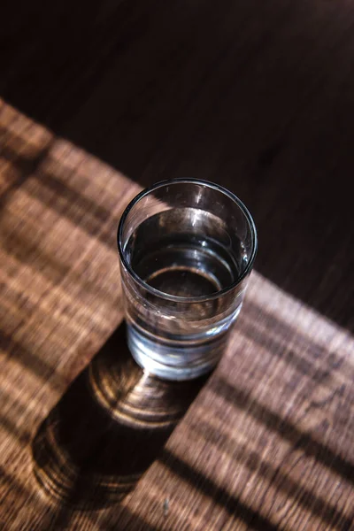 Colpo Verticale Bicchiere Acqua Tavolo Soleggiato — Foto Stock