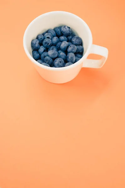 Vista Mirtilos Saborosos Doces Uma Chapa Fundo Laranja Com Espaço — Fotografia de Stock